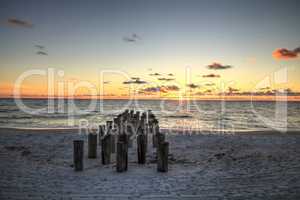 Dilapidated ruins of a pier on Port Royal Beach at sunset