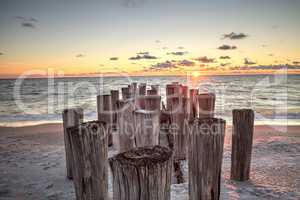 Dilapidated ruins of a pier on Port Royal Beach at sunset