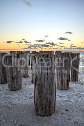 Dilapidated ruins of a pier on Port Royal Beach at sunset