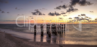 Dilapidated ruins of a pier on Port Royal Beach at sunset