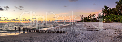 Dilapidated ruins of a pier on Port Royal Beach at sunset