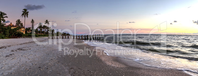 Dilapidated ruins of a pier on Port Royal Beach at sunset