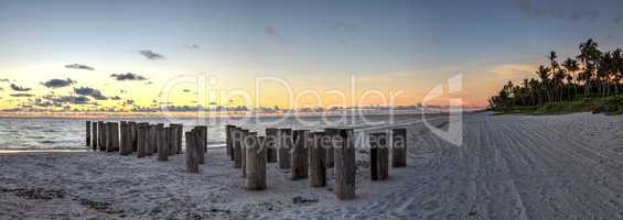 Dilapidated ruins of a pier on Port Royal Beach at sunset