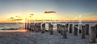 Dilapidated ruins of a pier on Port Royal Beach at sunset