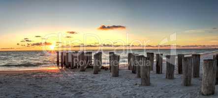 Dilapidated ruins of a pier on Port Royal Beach at sunset