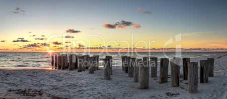 Dilapidated ruins of a pier on Port Royal Beach at sunset