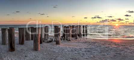 Dilapidated ruins of a pier on Port Royal Beach at sunset