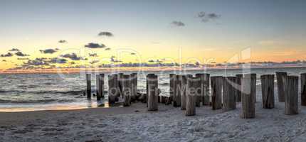 Dilapidated ruins of a pier on Port Royal Beach at sunset