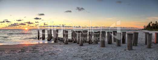 Dilapidated ruins of a pier on Port Royal Beach at sunset