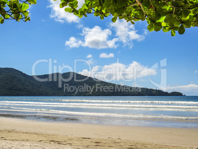 Landscape of beach with hills in the background.