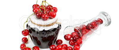 Cherries and jars of jam isolated on a white. Wide photo.