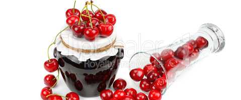 Cherries and jars of jam isolated on a white. Wide photo.