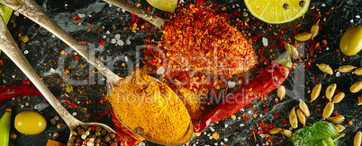 Variety of spices and herbs on kitchen table. Wide photo.
