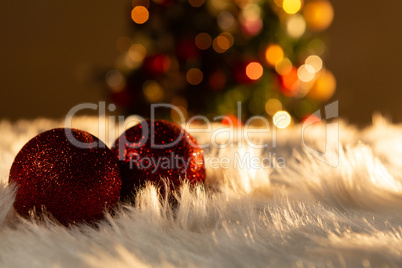 two red Christmas balls on a white fur