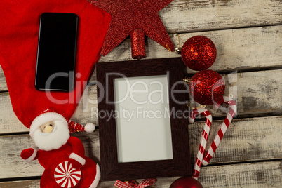 wooden frame with smartphone and Christmas ornament