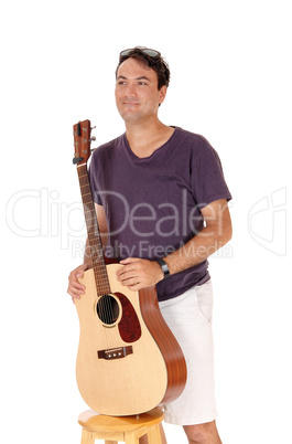 Man standing and holding his guitar, smiling