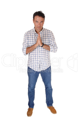 Young man praying with his hands folded, standing