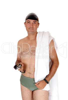 Young man in a swimsuit standing with towel over shoulder