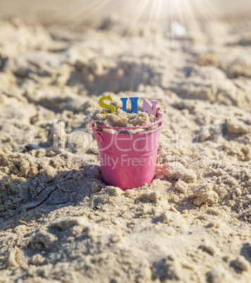 pink baby iron bucket filled with wooden colorful letters stands