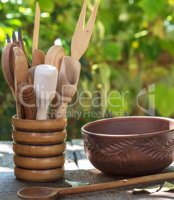 empty clay plate and various wooden kitchen objects