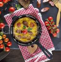 whipped eggs fried in a round black frying pan