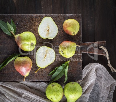 fresh ripe green pears lie on a brown wooden board