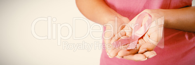 Woman displays pink ribbon in hands