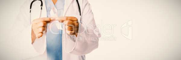 Smiling female doctor holding breast cancer awareness pink ribbon