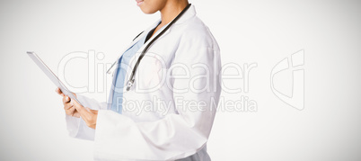 female doctor wearing breast cancer awareness pink ribbon holding a tablet