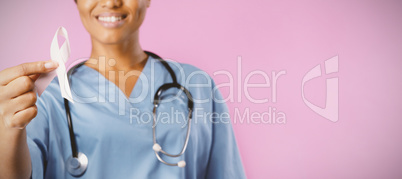 Smiling nurse holding breast cancer awareness pink ribbon