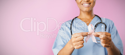 Nurse holding breast cancer awareness pink ribbon with both hands