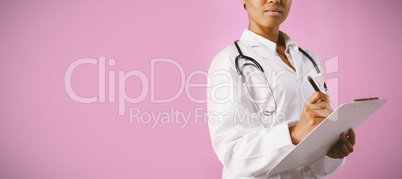 professionnal nurse with a pink ribbon writing on a note pad