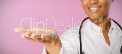 Smiling nurse shows a copy space with open hand