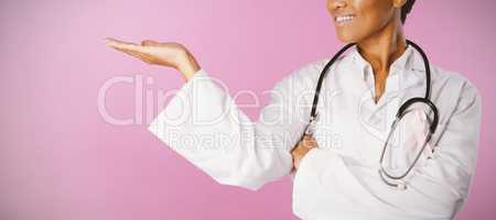 Nurse wearing breast cancer awareness pink ribbon shows a copy space