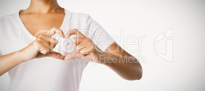 Women making heart shape with their fingers around pink ribbon