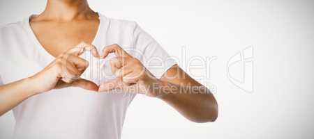 Women making heart shape with their fingers around pink ribbon