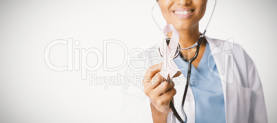 Female doctor holding a pink ribbon and a stethoscope