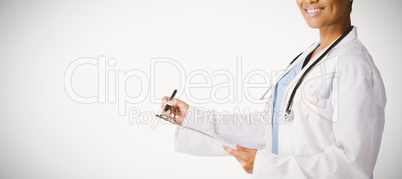 Smiling female doctor wearing breast cancer awareness pink ribbon writing on a note pad