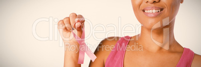 Smiling woman shows pink ribbon