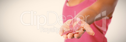 Woman stretches arm showing pink ribbon