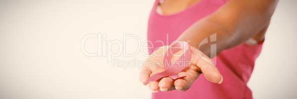 Woman stretches arm showing pink ribbon
