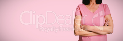 Composite image of  women in pink for breast cancer focus on crossed arms