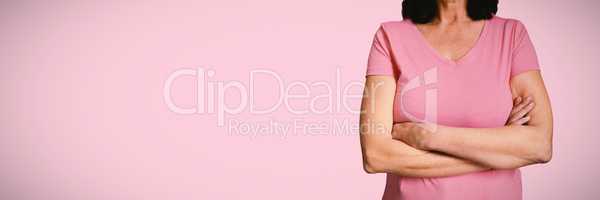 Composite image of  women in pink for breast cancer focus on crossed arms