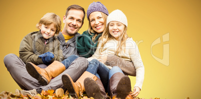 Composite image of portrait of happy family sitting on field at park