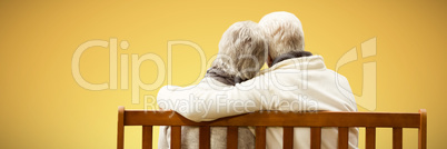 Composite image of  senior couple embracing on a bench