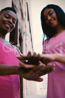 Women wearing pink for breast cancer and putting hands together