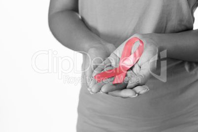 Woman displays pink ribbon in hands