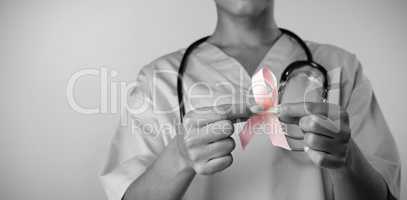 Nurse holding breast cancer awareness pink ribbon with both hands