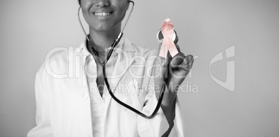 Smiling nurse holding pink ribbon breast cancer awareness