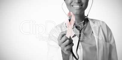 Female doctor holding a pink ribbon and a stethoscope